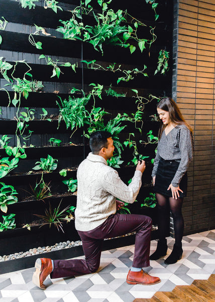 Man proposing in front of greenery