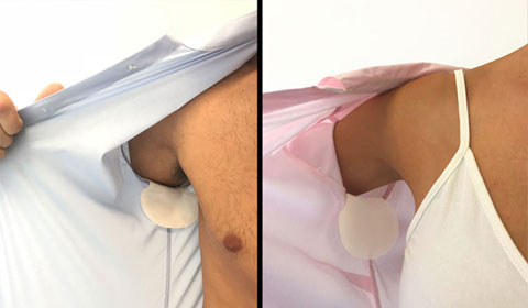 Man and woman applying dandi® patch underarm sweat pads. Use to stop pit stains, sweat marks, excessive sweating and hyperhidrosis perspiration.
