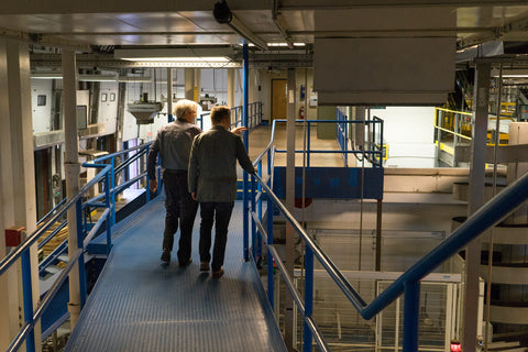 Owner of Moosehead Breweries, Derek Oland and Hartt Shoe Company CEO Andrew Bedford walk the on the catwalks in the Mooshead Brewery.