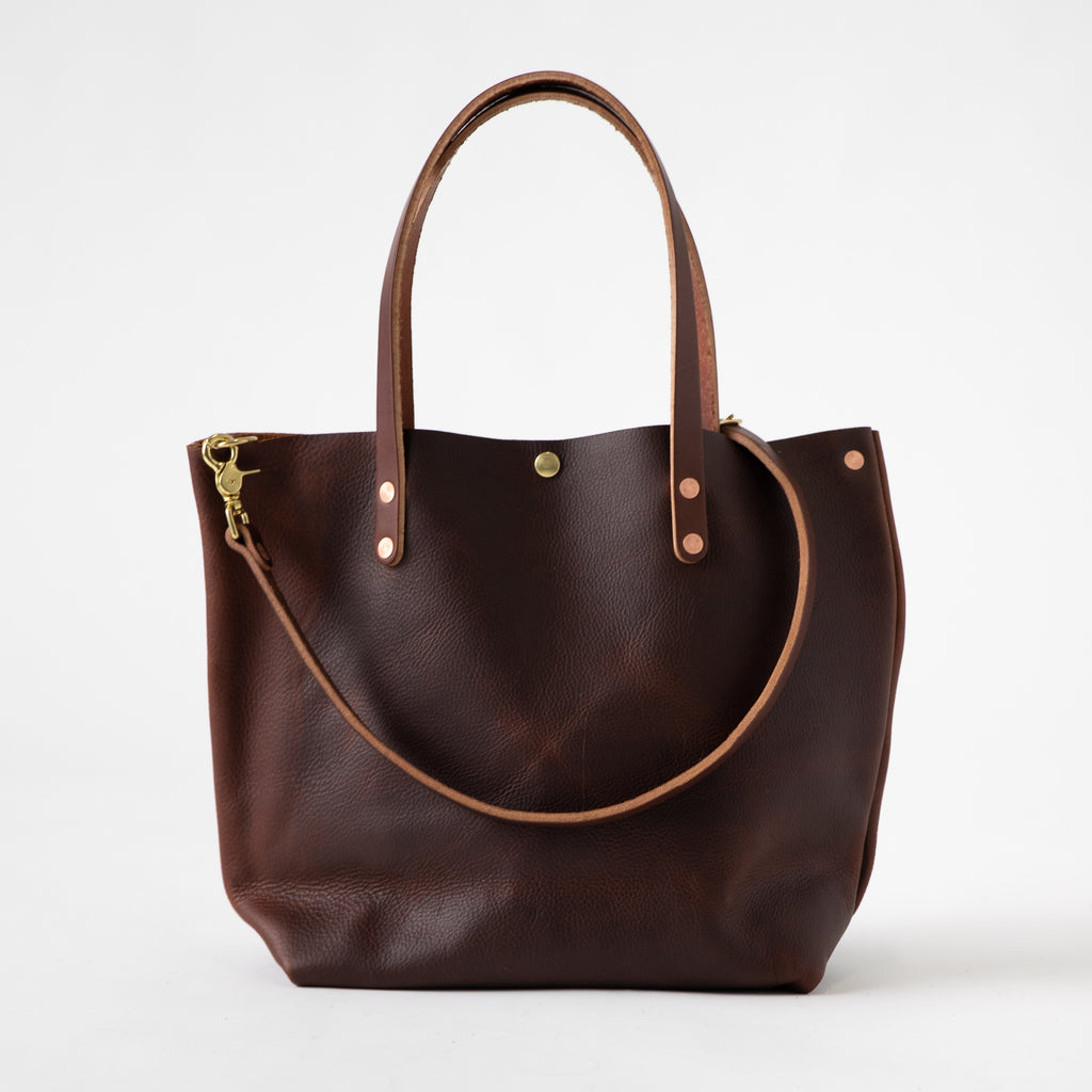 Brown Kodiak tote with crossbody strap and snap closure