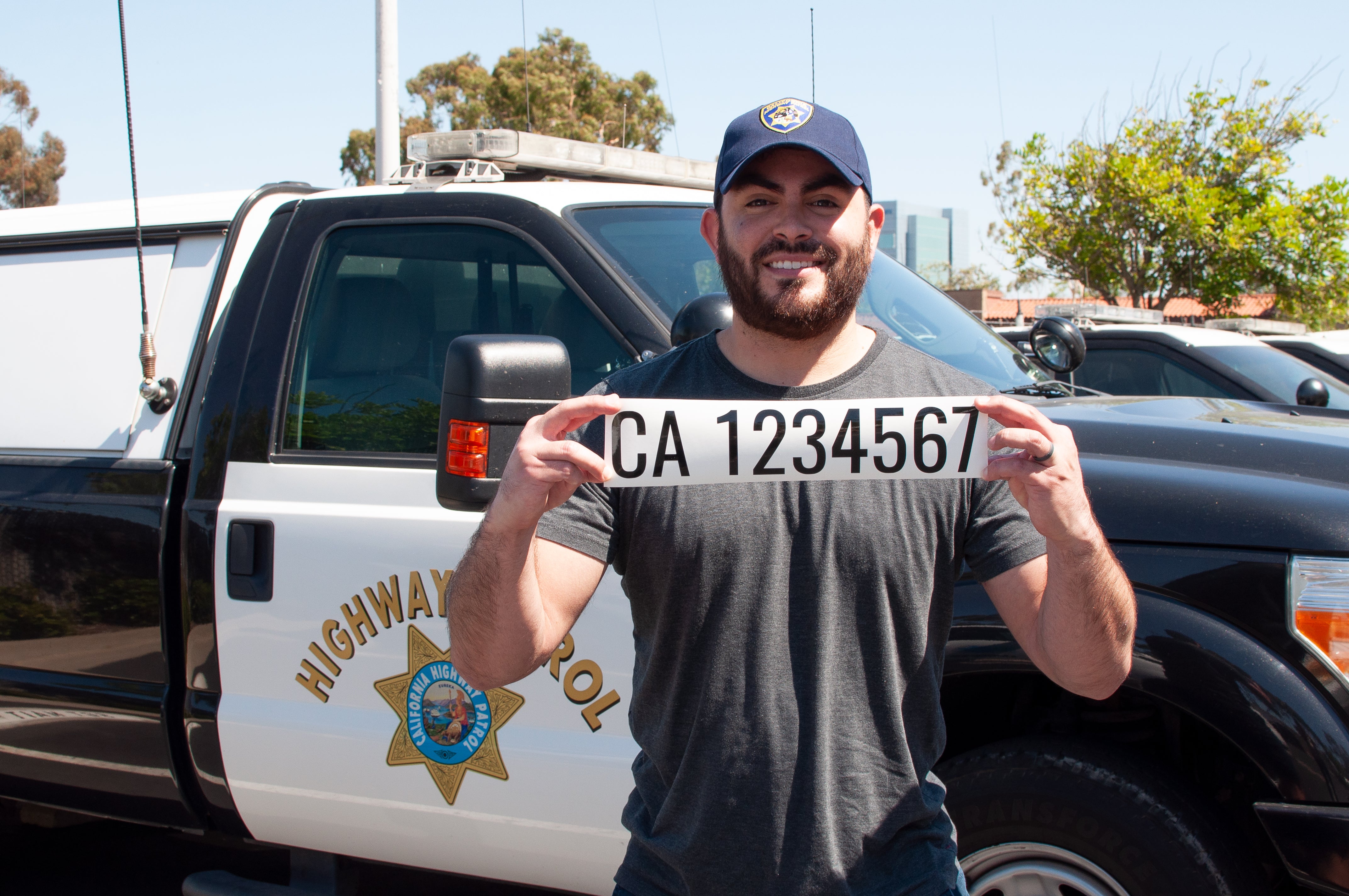 chp highway patrol officer holding a ca number decal