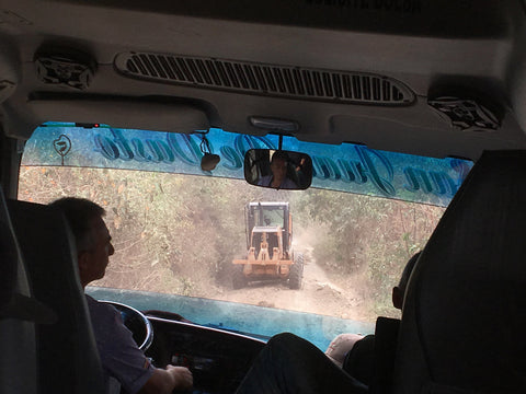 Looking out a jeep windshield at a tractor in Colombia