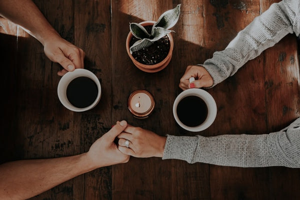 couple holding hands and drinking coffee