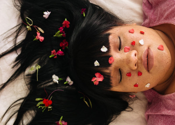 Sensual young lady with flowers in her hair meditating - orgasms and stress relief