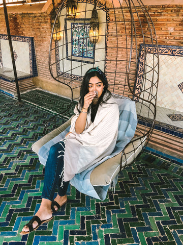 Ra'eesa sipping tea with her KISA Turkish Towel