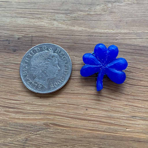 Wax carving of NI Silver's Shamrock necklace next to a 10 pence to show that they are the same size.