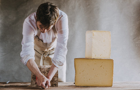 Cheese shop monger cracking cheese