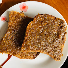 chai and pear jam on two pieces of toast on a white plate