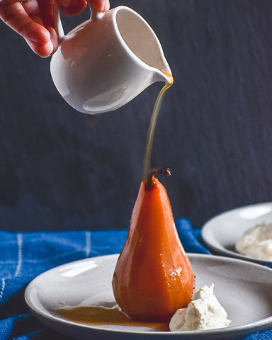 Chai syrup being poured over poached pear