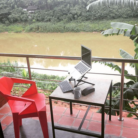 Kayla working on her laptop overlooking the Nam Khan river in laos