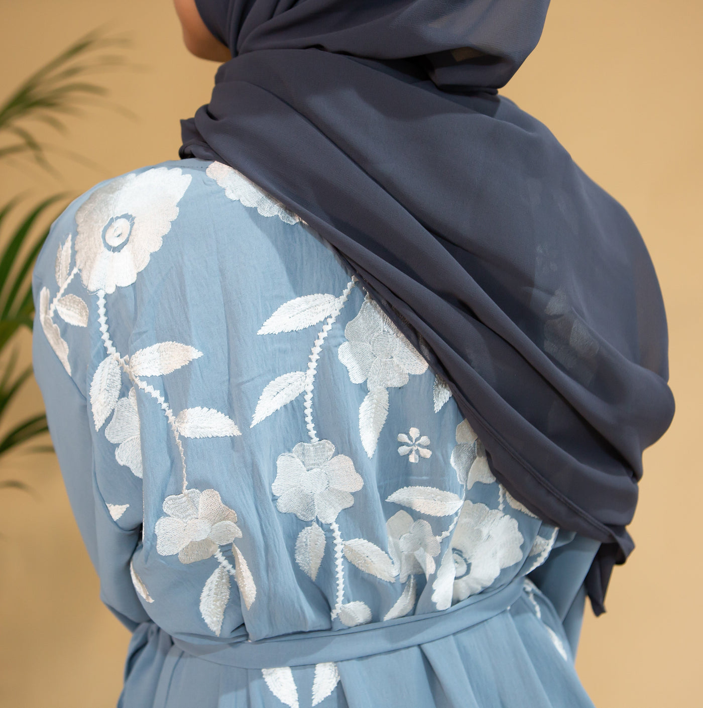 Aaliya Collections Blue Floral Abaya closed abaya of a pastel shade of blue with stunning contrasting white floral finishing