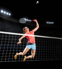 A person jumping to hit a shuttlecock over the badminton net