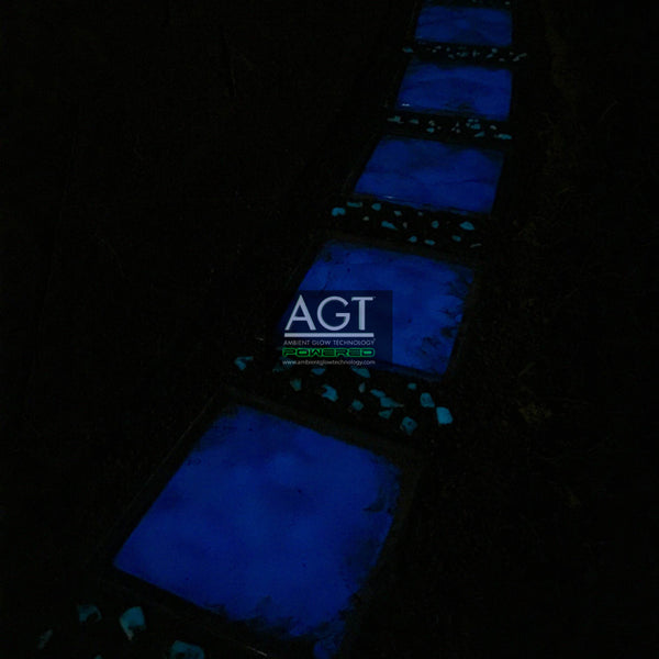 Night time close up view of glowing patio stones powered by AGT™ Sky Blue Fine Glow Sand.