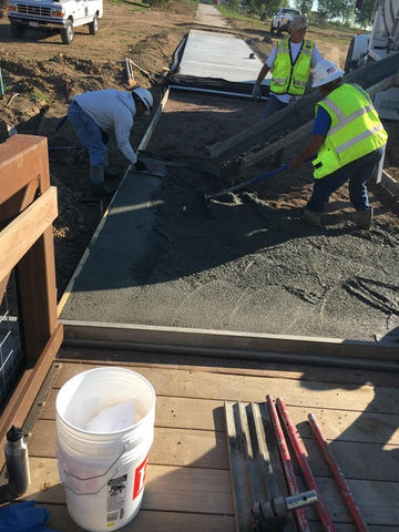 Concrete being poured and troweled out.