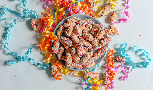 Birthday cake pretzel bites made with white chocolate, vanilla cookies and rainbow sprinkles