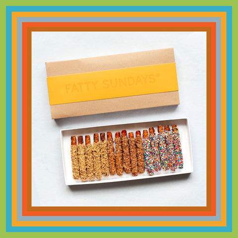 Yellow gift box with coconut, sprinkles and peanut butter flavored chocolate covered pretzels