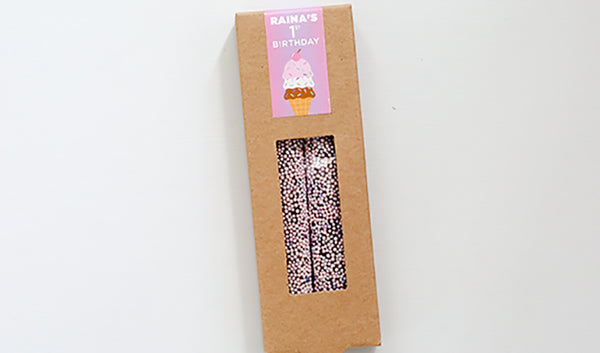 Kraft box of two pretzels with light pink and lavender sprinkles and customized birthday design