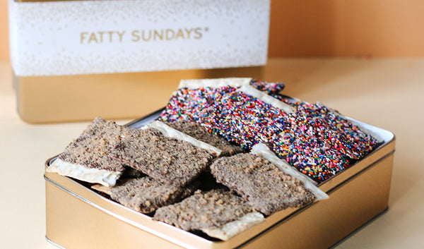 Golden tin filled with chocolate covered matzah covered in rainbow sprinkles and toffee bits