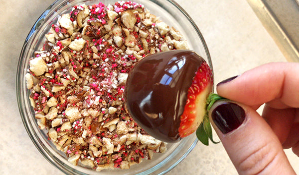 Chocolate covered strawberry dipped in chopped pieces of Valentine's Day sprinkle pretzels