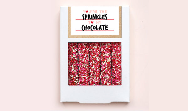 White box of five pretzels with red, pink and white sprinkles and customized Valentine's Day design 