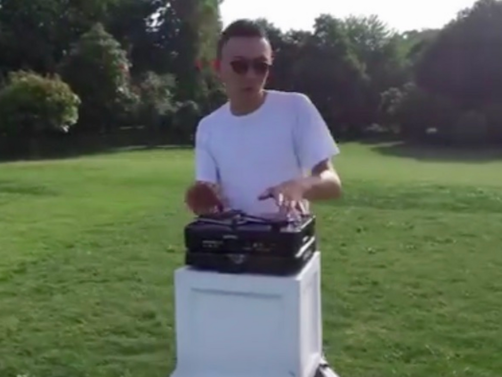 DJ Wordy using portable turntable in a field