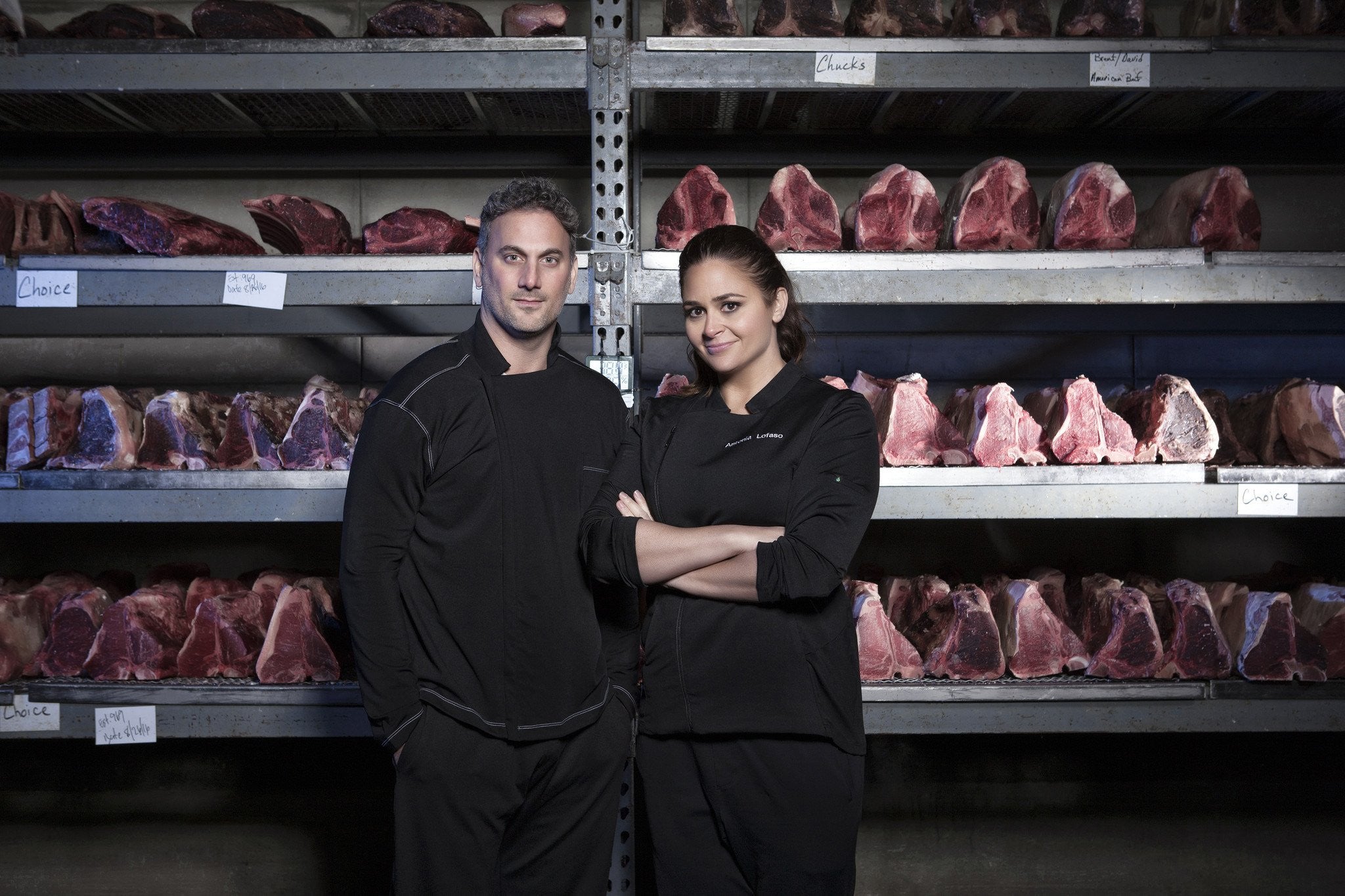 Salvatore and Antonia standing in front of shelves of meat
