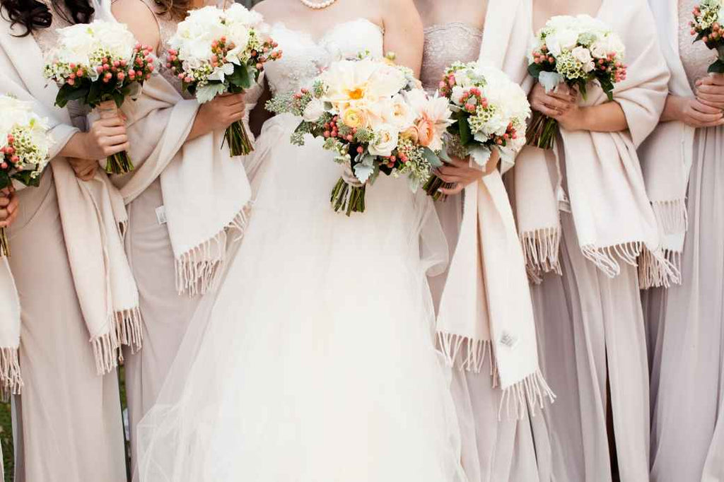 Bride and bridesmaids holding floral bouquets