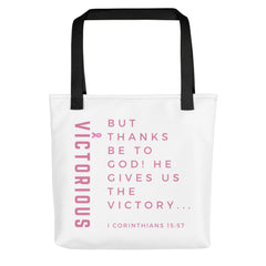 White color Tote bag with black color handles with words Victorious and a scripture verse about victory written on both sides of tote bag in pink color custom created and designed by vertical dominion 