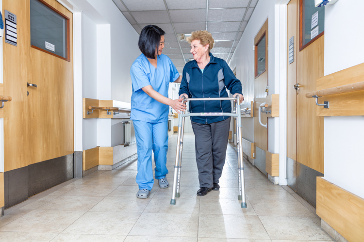 Recover quickly for your patients with PRO Compression socks. Nurse assisting woman with walker.