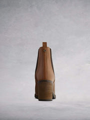 With a stacked leather veneer around a block heel with a contrasting brown rubber sole.