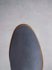 The blue suede boot has a smooth round toe shape.