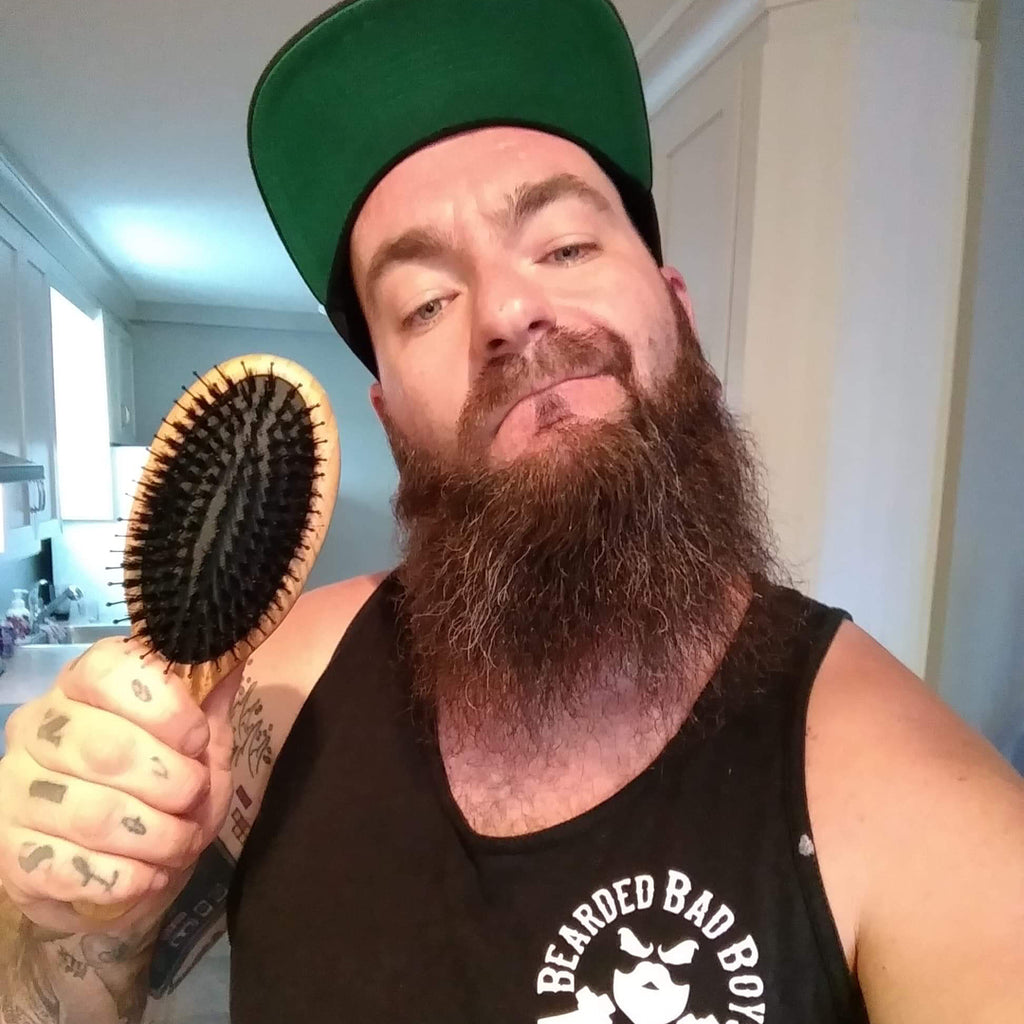 Man with long beard brushing beard