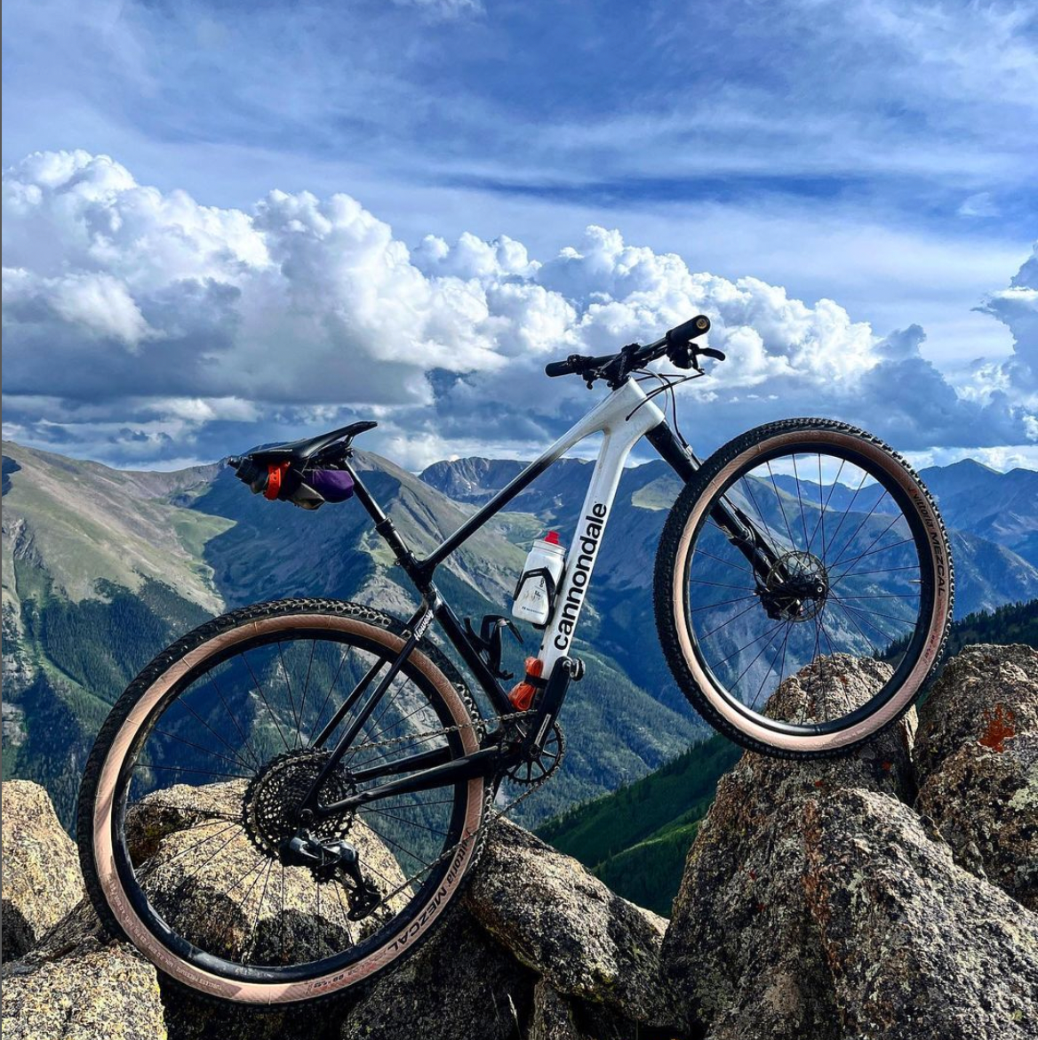 Alex Howe&#039;s bike at the top of a mountain on rocks