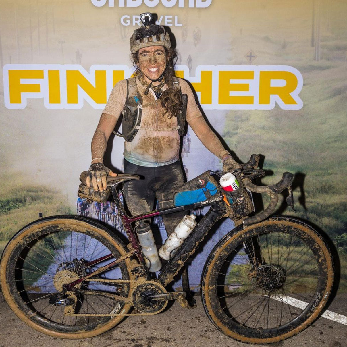 Meg Fisher covered in mud at the finish line for a race