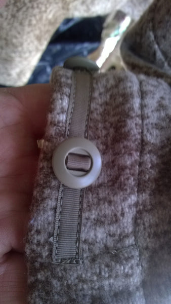 Slot buttons are attached to the garment by means of a nylon strip that runs through the button.  The nylon is sewn to the garment. Slot Buttons are far more secure than standard buttons.
