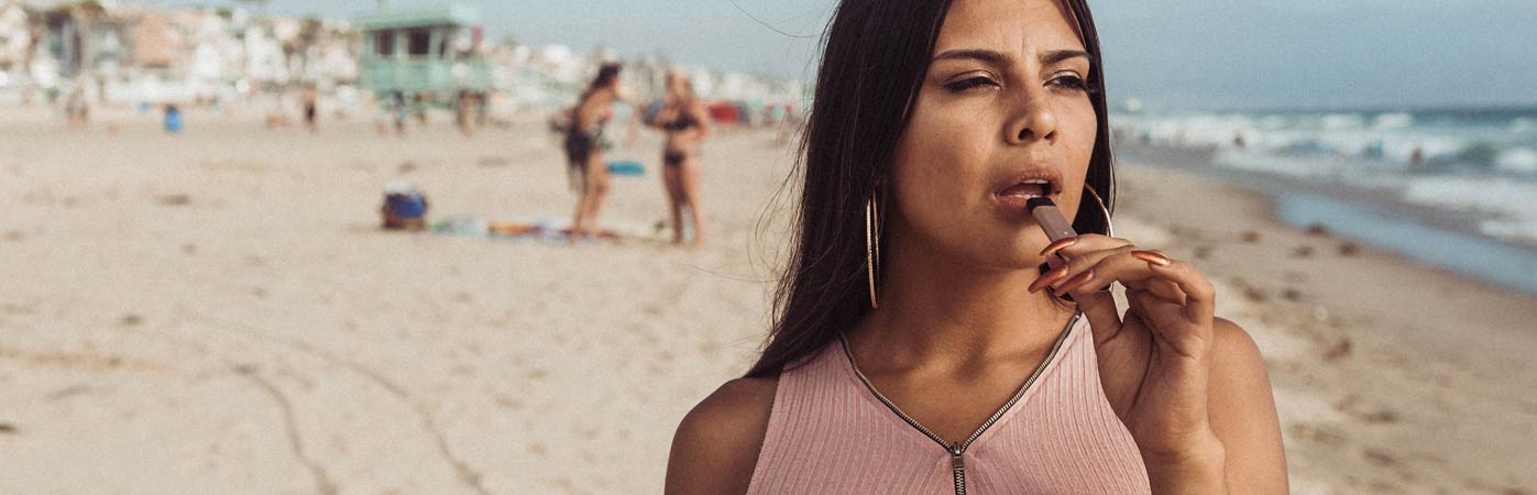 Woman vaping on beach