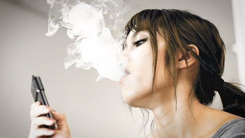 Woman using a convection vaporizer in her home