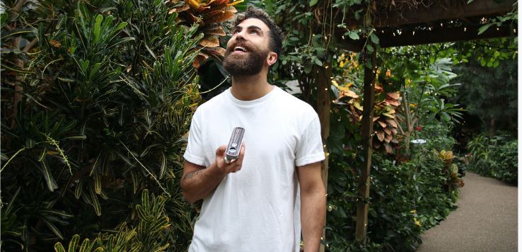 Bearded man enjoys Firefly 2+ Vaporizer in wilderness