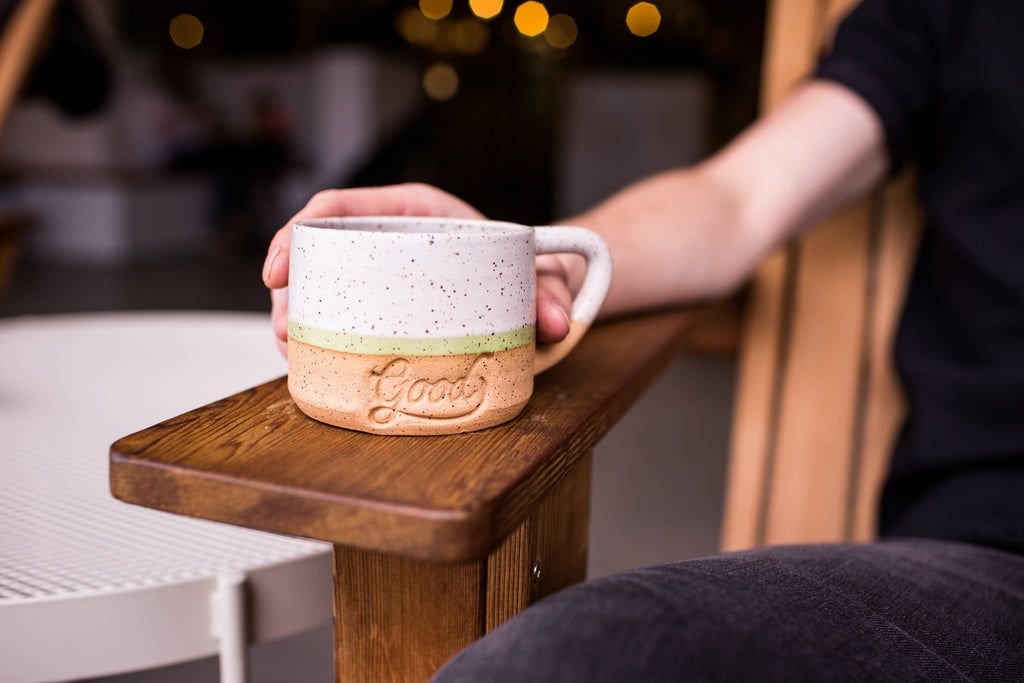 Customer enjoying coffee from ceramic mug at Good Coffee in Portland