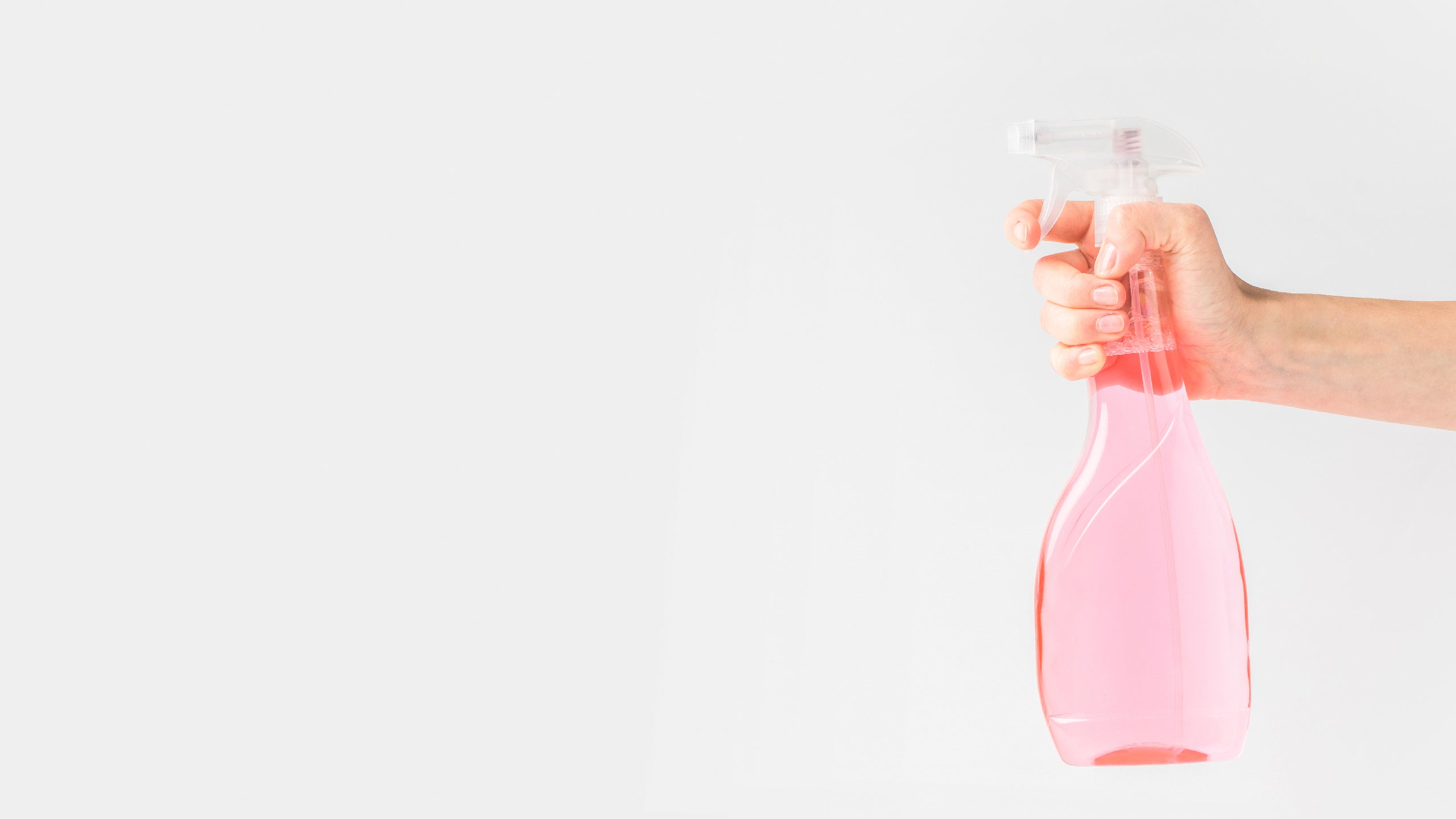 Stock photo of a hand squeezing a spritzer bottle