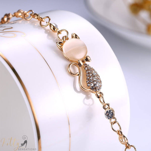 golden cat bracelet with an opal and berg crystals lying on jewelry box