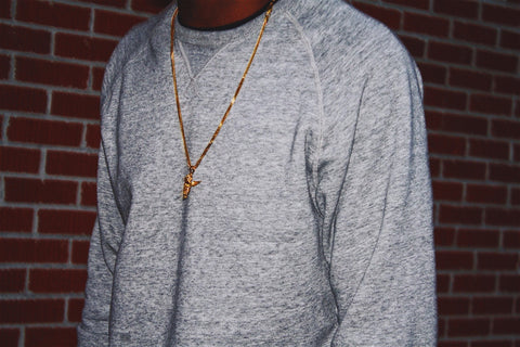 A person wearing a gold necklace.