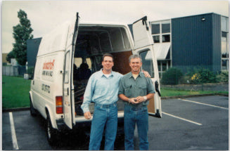 Scott and Ward Mayborn standing in front of a van filled with antiques.