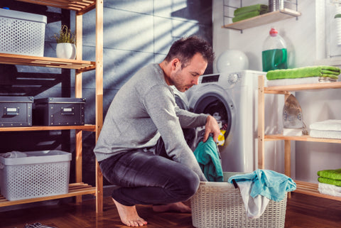 Man putting laundry into an eco-friendly washing machine