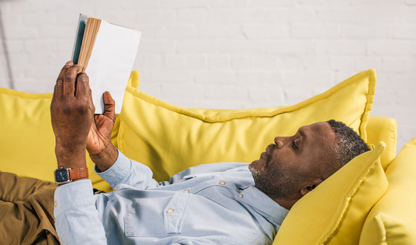 man lying on couch reading