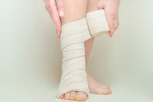 woman applying elastic compression bandage