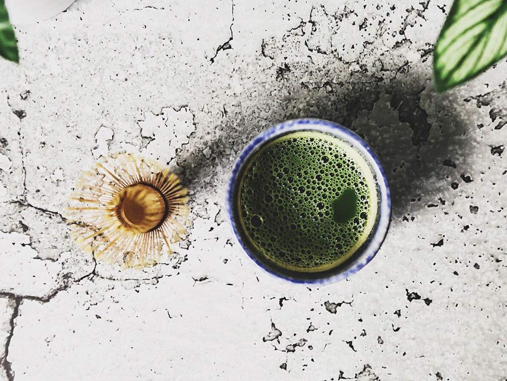 Cup of organic matcha with whisk