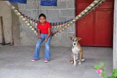 Brite Blue Guatemalan girl in hammock with dog