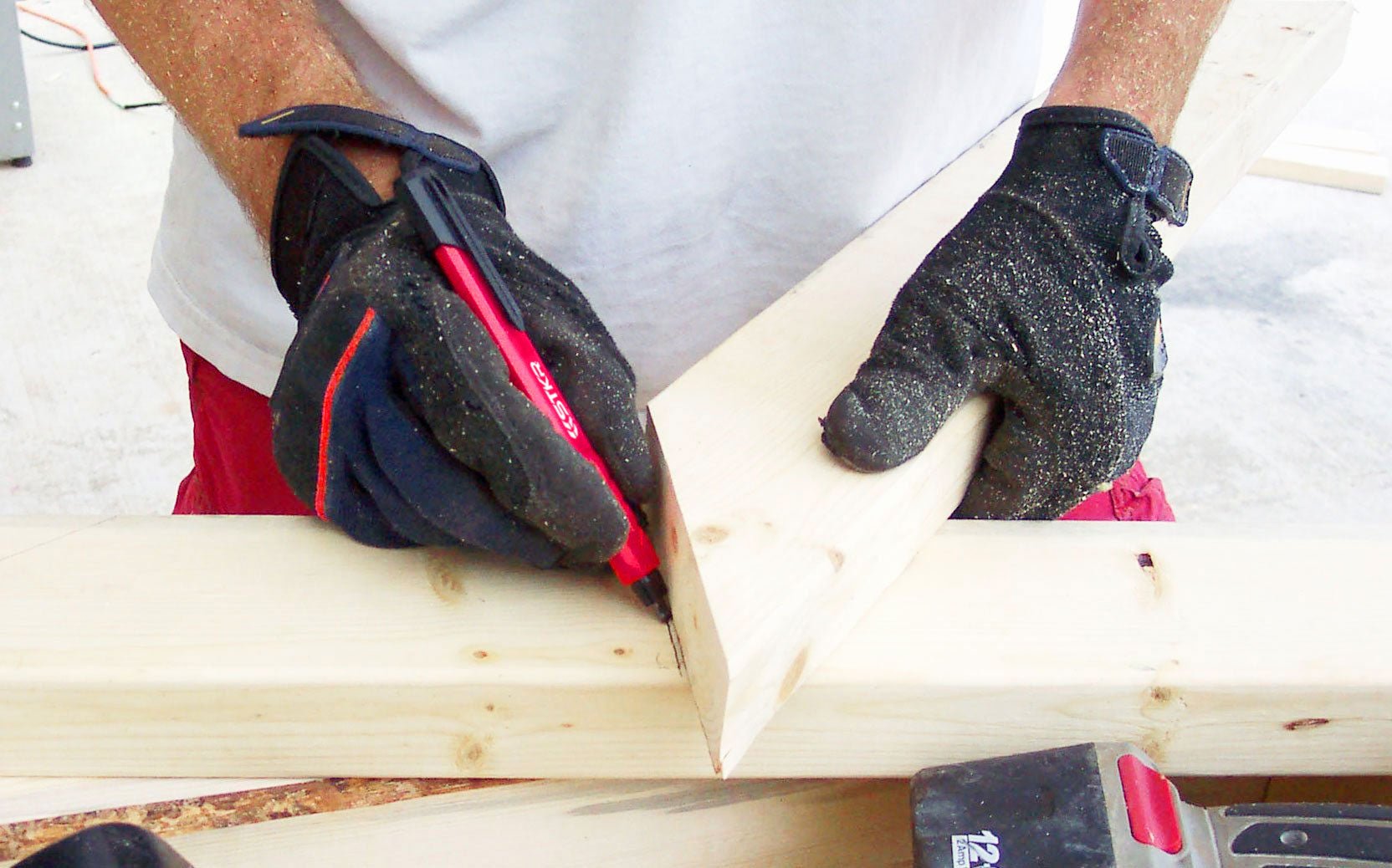 framer holding two 2x4's one over the top of the other to mark an angle using STKR's Mechanical Carpenters Pencil