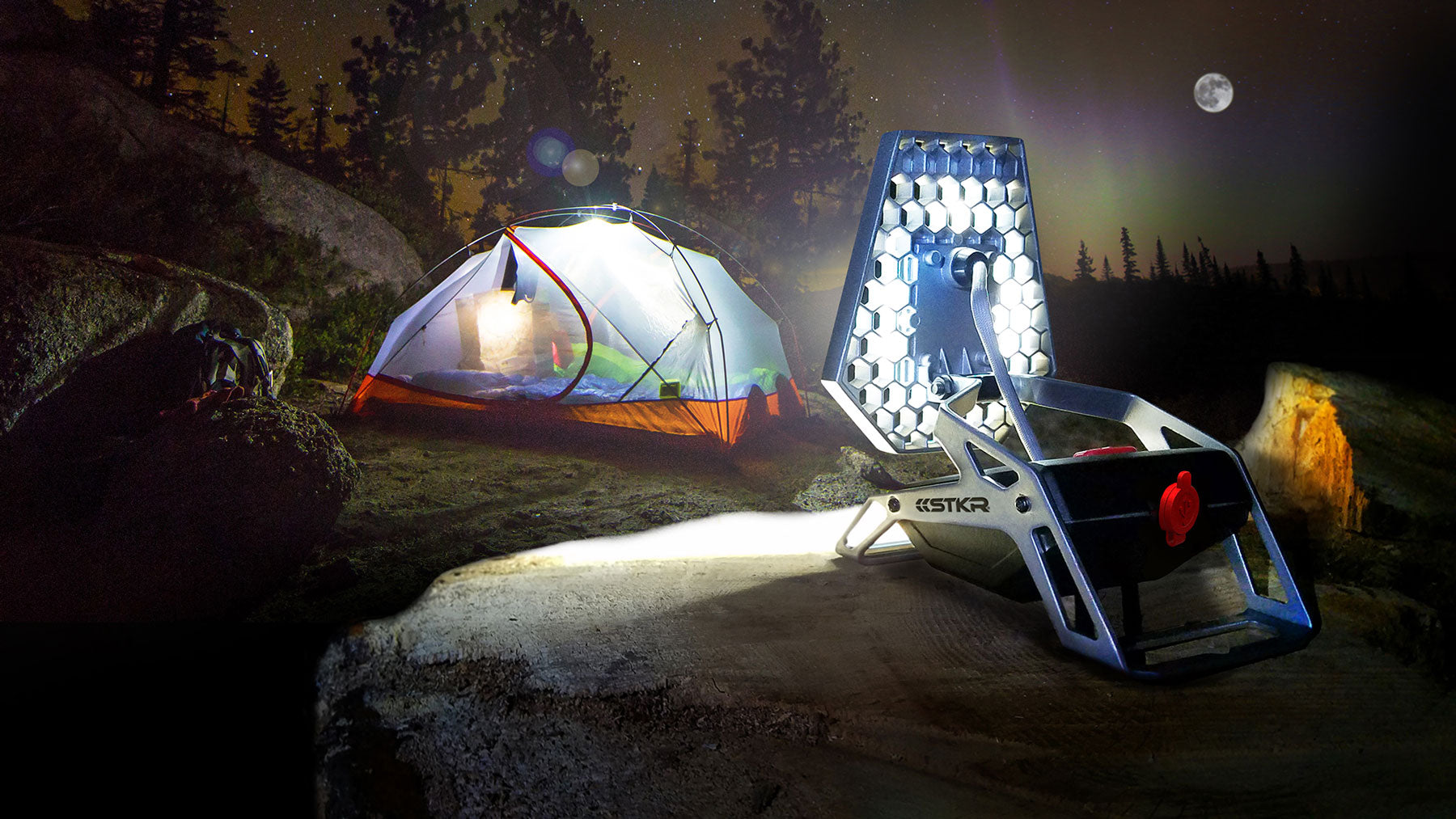 night time mountainous camping scene featuring a mobile task light illuminating a tent camp spot.